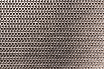 Metallic honeycomb hexagon grilled pattern in front of music speaker as background