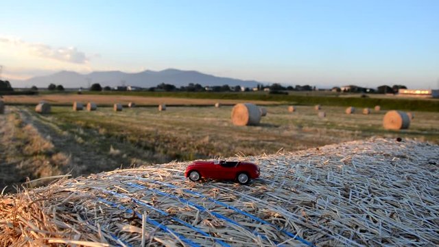 Toy car on a round straw bale