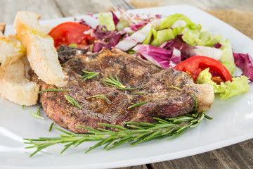 Braciola di maiale arrosto con contorno di insalata fresca e crostini 