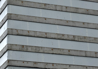 old concrete highrise building covered in plastic sheeting during demolition