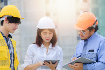 Woman engineer discussing building project with foreman and worker on site workplace, Engineer checking work for control on site concept