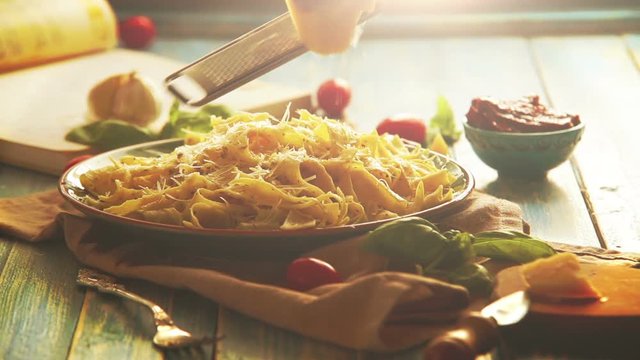 Warm colors footage: hard cheese is grated on the beautiful plate of fresh pappardelle