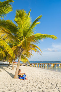Mano Juan, Saona Island, East National Park (Parque Nacional del Este), Dominican Republic, Caribbean Sea. Woman relaxing on the palm-fringed beach (MR).