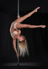 Beautiful slim girl with pylon. Female pole dancer woman dancing on a pole