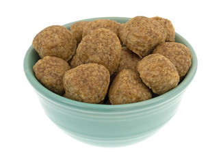 Chicken meatball dog food in a green bowl isolated on a white background.