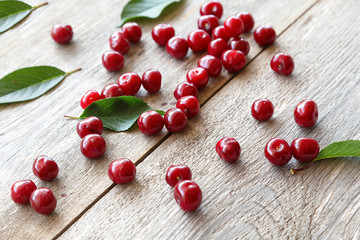 Fresh cherries scattered on a wooden background
