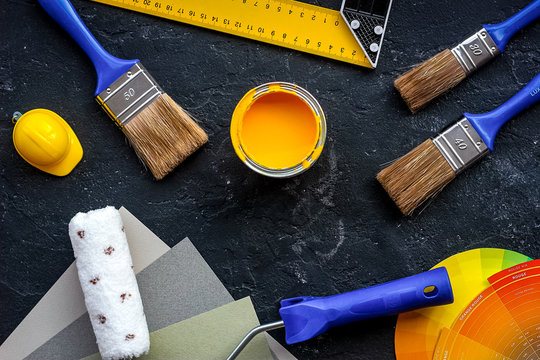 decorating and house renovation tools and accessories on black stone table background top view
