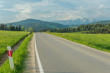 Asphalt road, mile marker and Tatra mountains