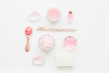 body treatment with rose extract and cosmetic set white desk background top view
