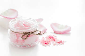 Obraz na płótnie Canvas body treatment with rose petals and cosmetic set white desk background