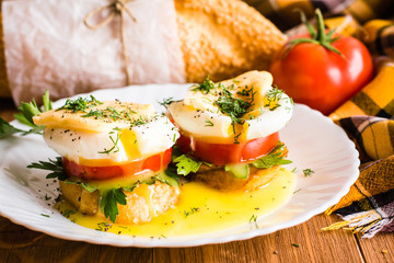 Sandwiches with poached egg, tomato, parsley and cheese
