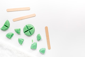 Wax and sticks for depilation on white background top view copyspace
