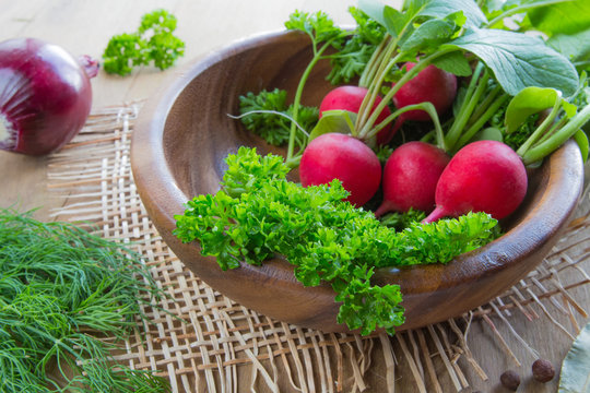 Fresh fragrant herbs spices parsley onion dill pepper bay leaf and juicy ripe radish vegetables. The concept of healthy nutrition and vegetarianism