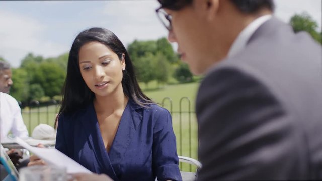 Business people having meetings outdoors on bistro tables, in slow motion