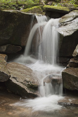 Beautiful waterfall with moss on the stones in the woods.