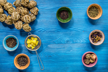 Tea-party with different herbal tea on blue desk background flat lay mock up
