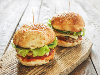 Delicious homemade burgers on wooden background