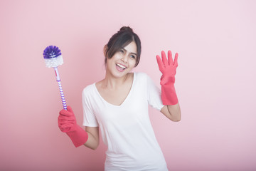 Beautiful asian housewife smiling on pink background