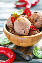 Bowl with chocolate ice cream and chili pepper.