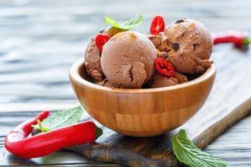 Balls of chocolate ice cream with chilli in a wooden bowl.