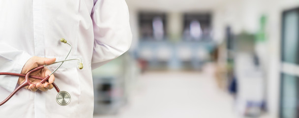 Obraz premium male doctor holding a stethoscope in a hospital,medical students during the conference,Health Check with digital system support for patient,test results and patient registration,selective focus