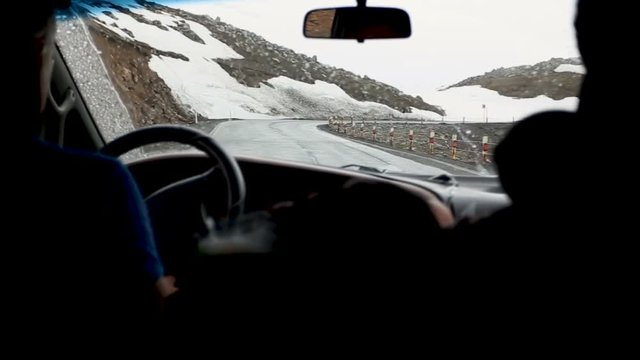 Travel by car. Road trip through snowy mountains. Shooting from the passenger seat. Kazbegi, Georgia.