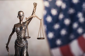 Statue of justice on flag background.