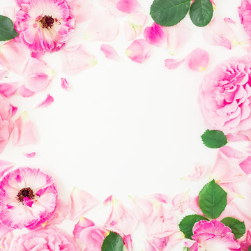 Round floral frame of pink ranunculus flowers, roses, petals and leaves on white background. Floral lifestyle composition. Flat lay, top view.