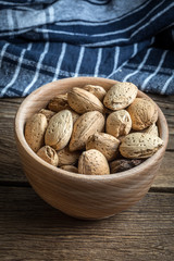 Almonds in-shell in wooden bowl.
