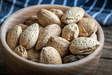 Almonds in-shell in wooden bowl.