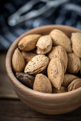 Almonds in-shell in wooden bowl.