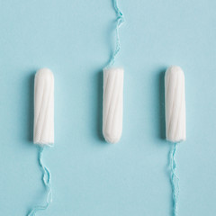 Menstrual tampon on a blue background. Menstruation time. Hygiene and protection