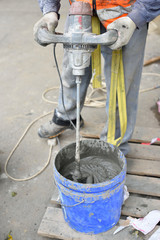 Mixing cement with a mixer in a bucket on the street
