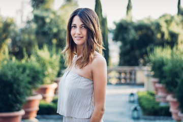 Young elegant woman outdoor in a romantic tuscany garden. Florence - Italy.