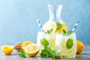 Lemonade or mojito cocktail with lemon and mint, cold refreshing drink or beverage with ice.