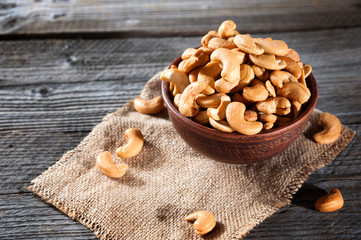 Raw cashews in bowl on wooden table