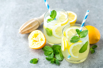 Lemonade or mojito cocktail with lemon and mint, cold refreshing drink or beverage with ice.