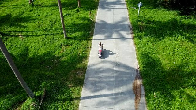Aerial View of Young Woman Riding Scooter in Thailand