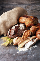 Different kinds of bread and bread rolls on board from above. Ki