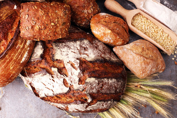 Different kinds of bread and bread rolls on board from above. Kitchen or bakery poster design.