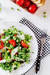 Fresh and healthy fitness salad with lettuce, peas, cherry tomato, cucumber, green onion, dill, sunflower or olive oil and toast on a white background