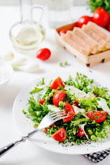 Fresh and healthy fitness salad with lettuce, peas, cherry tomato, cucumber, green onion, dill, sunflower or olive oil and toast on a white background