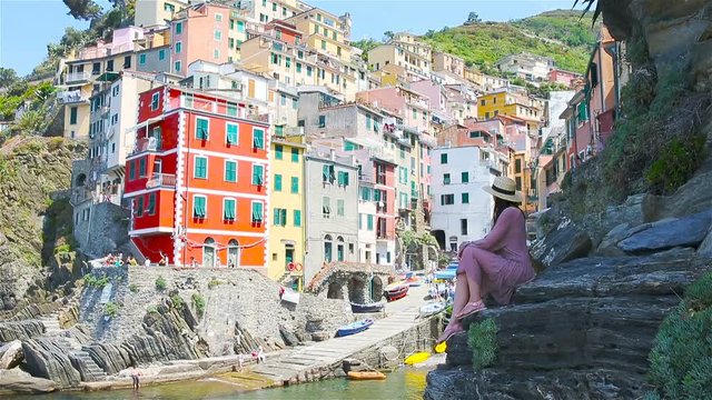 Young woman with great view at old village Riomaggiore, Cinque Terre, Liguria, Italy. European italian vacation.