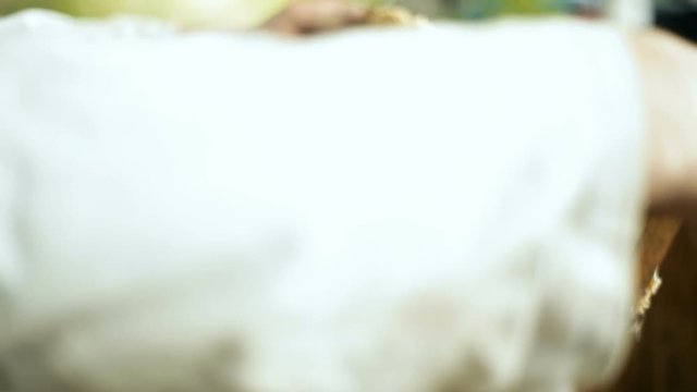 A beekeeper hiver man, checks how the bees prepare honey, work, in an open beehive with wooden racks and waxen honeycombs. Pulls out the rack.