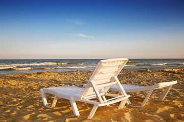 Two deckchairs on the sandy beach