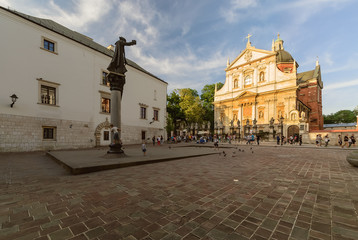 Obraz premium Square, monument and church in Krakow, Poland in the evening