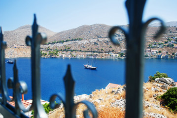 Blue sea.  Sea view from the fortress, through the fence, where you can see a big ship, yacht