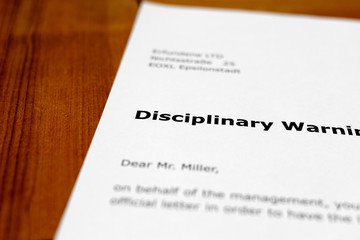 A letter on a wooden table - disciplinary warning