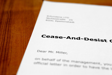 A letter on a wooden table - cease and desist