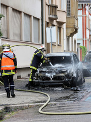 Obraz premium Burnt out car and firemen